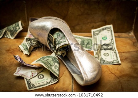 a white white wedding shoe full of dollars and currency. ritual at some weddings-the shoe is filled with money then the bride is given to the groom.