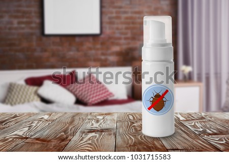 Bottle of anti bed bug detergent on table in bedroom