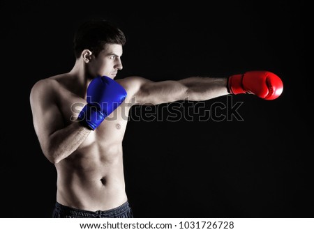 Man wearing red and blue boxing gloves on black background. Concept of political confrontation between American major parties - Democratic and Republican