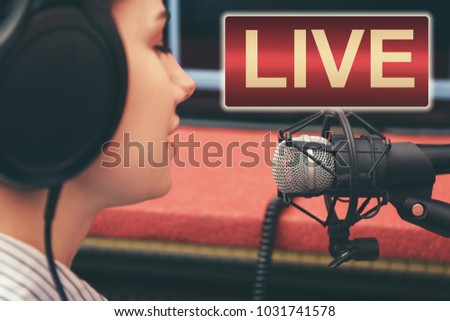 Young woman taking part in live radio broadcast at modern studio
