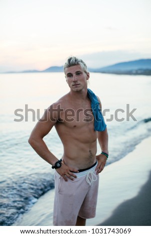 Handsome sporty Caucasian man standing by the sea.