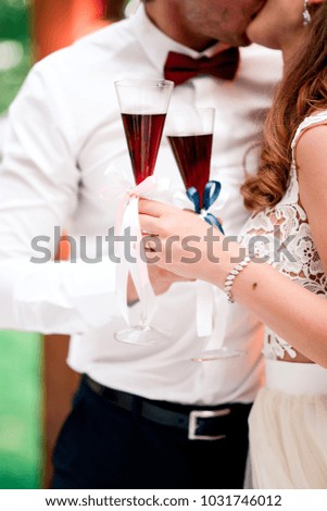 wedding glasses with champagne in hands of bride and groom
