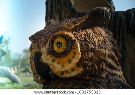 wood owl statue head shot focus big yellow eye ,copy space by the left hand
