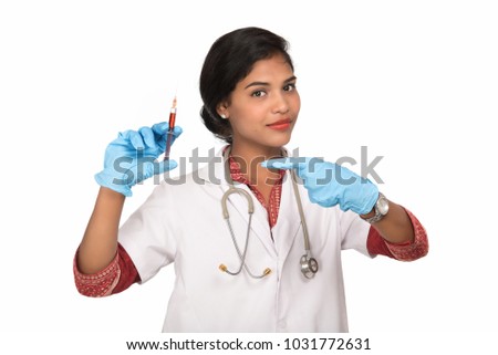 Female doctor with stethoscope is holding injection.