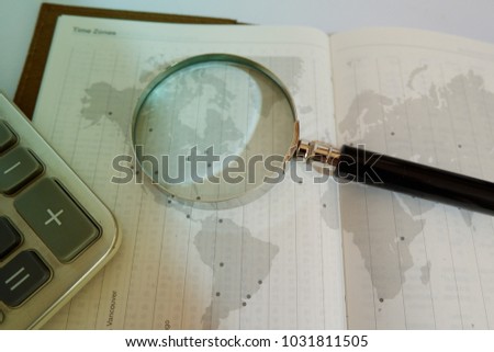 diary page close up and world map with  magnifying glass and calculator. global business marketing  concept. business background with copy space.