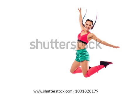Cheerful young woman jumping and dancing zumba on white background. Copy space.
