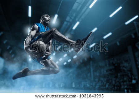 Basketball player in motion or movement on big professional arena during the game. Player making slam dunk. unbranded uniform. attack and decisive blow concept. professorial afro american athlete
