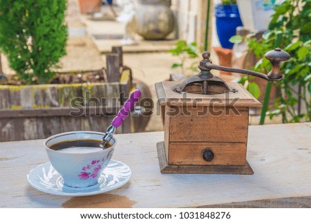 cup of coffee and old coffee grinder outdoors