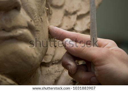 Sculptor artist creating a bust sculpture with clay Royalty-Free Stock Photo #1031883907