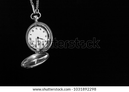 A pocket watch on a black background. A blank space for text.