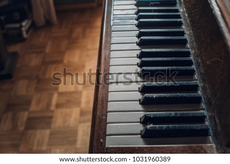 Closeup of an old wooden piano and keyboards in a bedroom