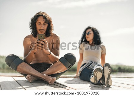 Love couple by a lake at sunny day relaxing.
