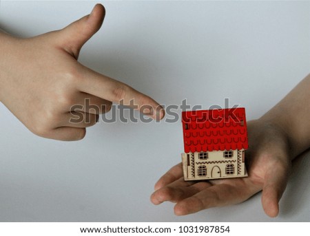 Red roofed wooden house in hands