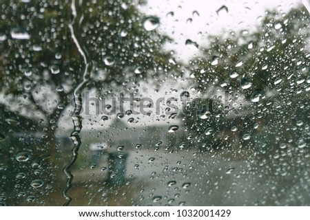Drops of rain on the window, rainy day, dark tone. Shallow DOF

