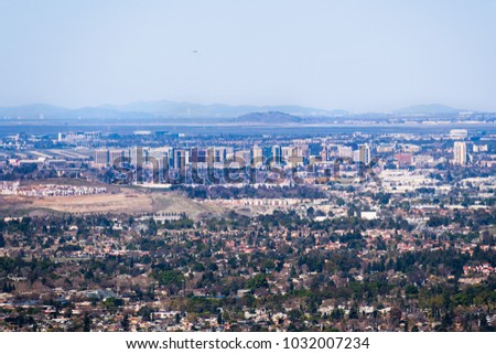 Aerial view of downtown San Jose on a clear day; residential neighborhoods in the foreground; Santa Clara and San Francisco bay in the background; Silicon Valley, California