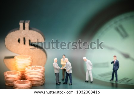 Miniature people: Business man team hand shake and stack of coins, wooden dollar with copy space using as background sale, buy, trade, business time concept.