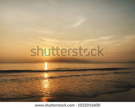 Beautiful view from the beach to sunrise upon foggy islands in the sea