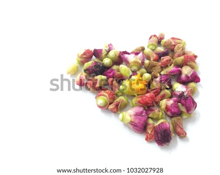 making heart shape by little colorful dried flowers on white background