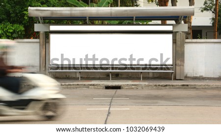 The motorcycle driving through the station stop bus and a billboard on the bus station