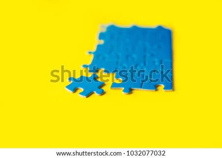 Blue jigsaw puzzle on yellow backgorund, business connection, success and strategy concept, teamwork