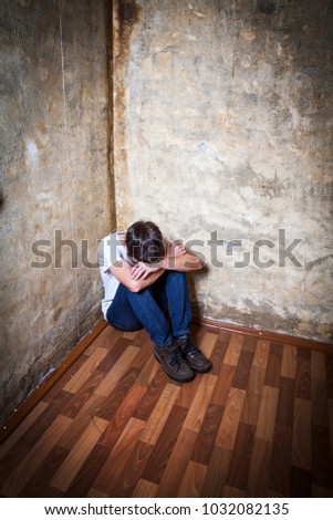 Vignetting Photo of Sad Young Man in the Corner by the Old Wall