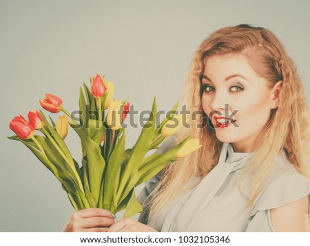 International women day, eight march. Beautiful portrait of pretty woman blonde hair with red yellow tulips, fashion make up. Mother day. Toned image