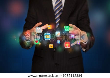 Elegant businessman holding colorful mixed media icons 
