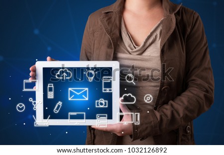 Casual young woman holding tablet with multimedia icons 