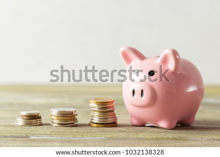 piggy bank with coin on old wooden table