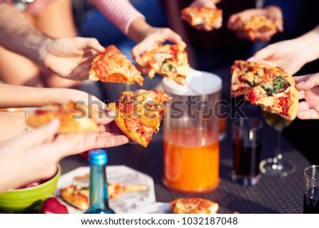 Tasty dish. Close up of pizza pieces in hands of nice people eating it while having lunch together