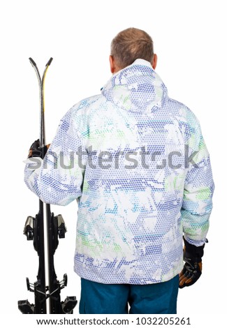 Senior man wearing ski suit, holding skis on isolated - back view