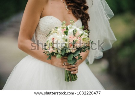 Beautiful bridal bouquet. Wedding floristry. A bouquet in the hands of the bride.