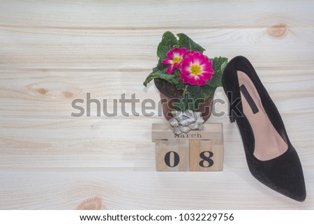 Black women's shoes by March 8. Heeled shoes and wooden calendar. Design a lovely gift. Background with space for message. Mother's Day background.