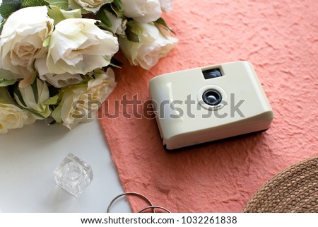 Vintage camera with flowers on peach color background