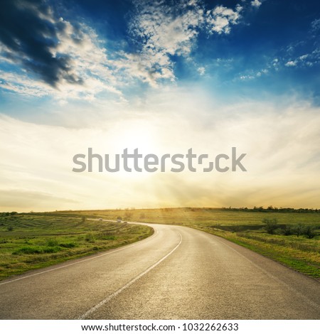 road to horizon in sunset. Low clouds with sun over asphalt way Royalty-Free Stock Photo #1032262633