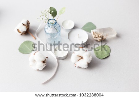 Cute flat lay top view photo with gentle flowers and plants. Feminine stock image. Hearts, cotton, bottles and jars and an angel figure.