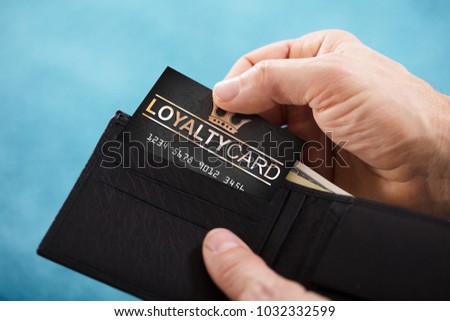 Close-up Of A Person's Hand Removing Black Loyalty Card From Wallet Royalty-Free Stock Photo #1032332599