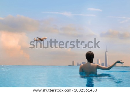  Young female in the pool on the roof on the background of skyscrapers of New York City, Manhattan