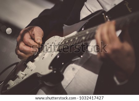 Rock music background, bass guitar player, closeup photo with soft selective focus