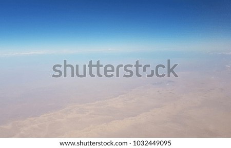 Blue sky high above the clouds at 10,000 ft. Aerial view on Egypt. 
