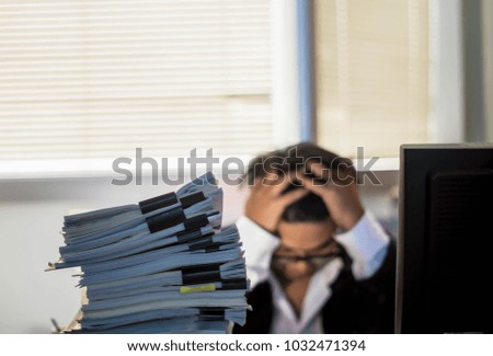 Young businessmen feel stressed and confused. With computer And many documents After the news The company faced financial difficulties. The view behind the blurred. The concept of stress, businessmen
