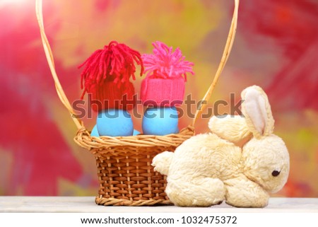 happy easter egg easter blue eggs as smurfs in winter hats red and pink color in straw basket and rabbit or hare toy on colorful background, healthy food greeting and celebration, future life, farming