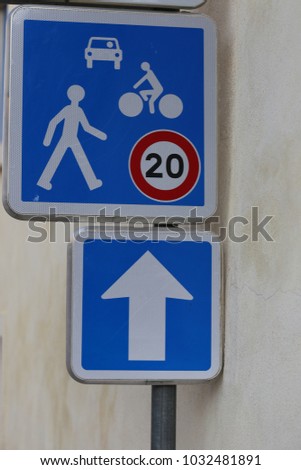 Close up view of a french traffic sign in a pedestrian street. Symbol indicating that the speed is limited at 20 kilometers per hour for cars and cycles. Blue and white metallic sign, Urban image.  