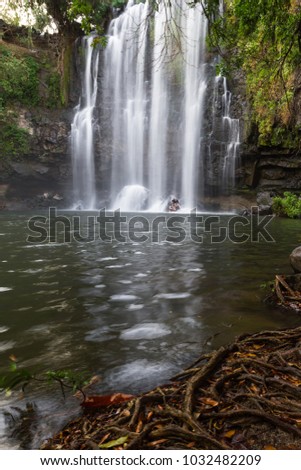 couple enjoying a dip in the warm water of this beautiful waterfall in Costa Rica, Llanos del Cortez