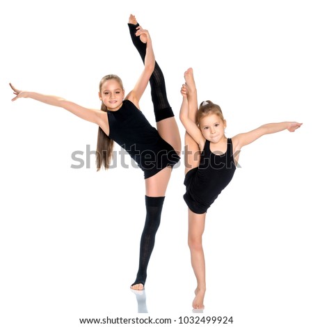 Lovely little girls gymnasts warm up before the competition. The concept of a happy childhood, sports and fitness. Isolated on white background.