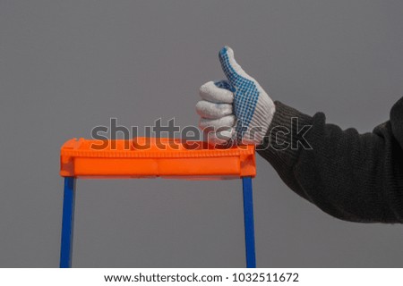close up of man showing thumb stands near the ladder