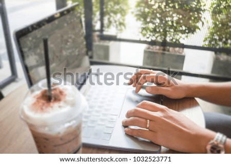 Woman hand on laptop keyboard with morning coffee