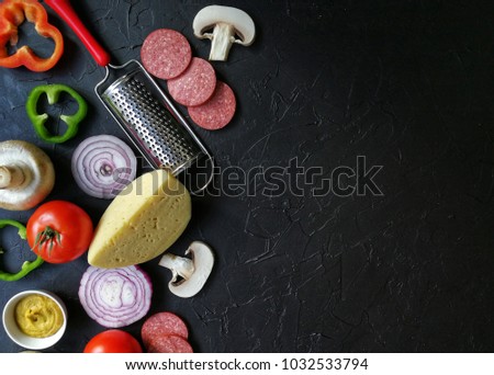 the ingredients for a recipe for cooking pizza on the black textured concrete background 