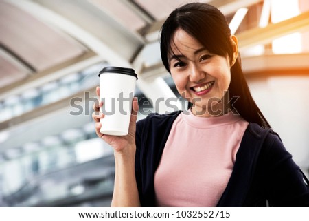 beautiful women holding coffee cub for happy before work.