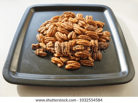 A bunch of nuts pecan on a black plate. Close-up photo
